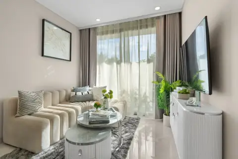 1 Bedroom Condo for Sale at Copacabana Coral Reef lounge area with beige sofa, wall-mounted TV and sheer curtains