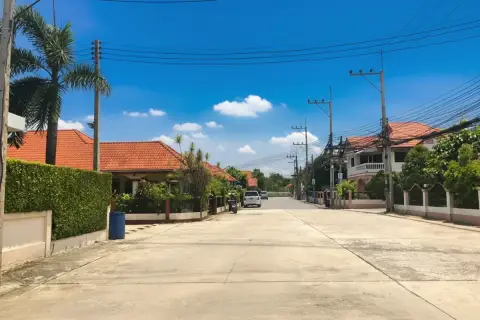 Country Club Villa street view with houses, red tiled roofs, palm trees, and overhead power lines.
