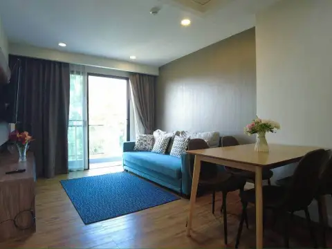 2 Bedroom Condo for Sale at Dusit Grand Park 1 living area with balcony access, sofa, and wooden dining table