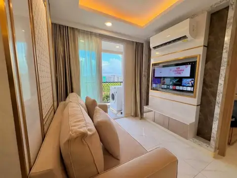 1 Bedroom Condo for Sale at Dusit Grand Park 2 lounge area with sofa, smart TV and balcony with washing machine