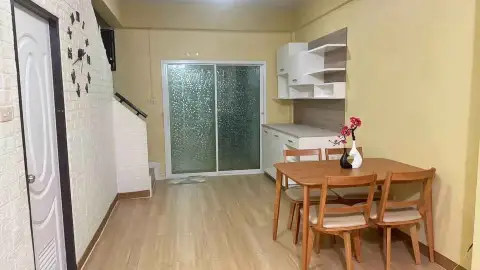 2 Bedroom Townhouse for Rent in East Pattaya dining area with wooden table, chairs, and kitchen shelving