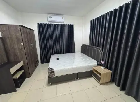 3 Bedroom Townhouse for Rent in East Pattaya bedroom with double bed, dark curtains, and wardrobe