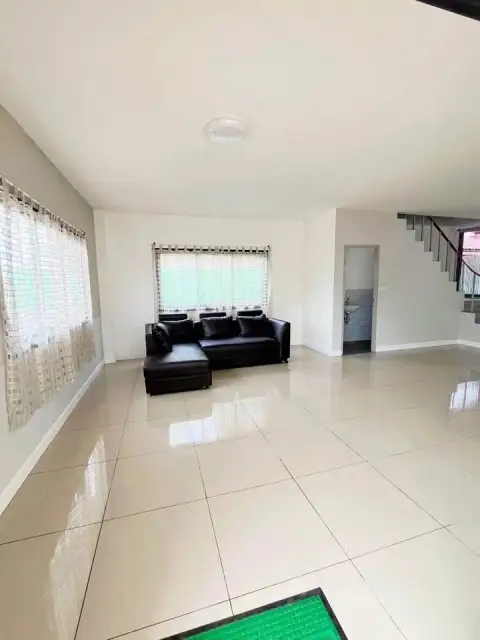 3 Bedroom House for Sale in East Pattaya spacious living room with black leather sofa and tiled flooring
