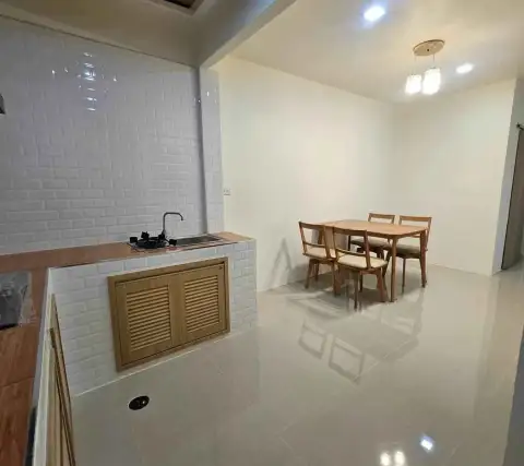 2 Bedroom Townhouse for Sale in East Pattaya open-plan kitchen with white brick tile backsplash and adjoining dining area