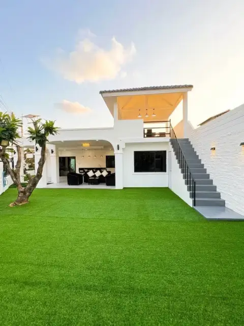 3 Bedroom House for Rent at Ekmongkol 1 Village exterior view with rooftop terrace, staircase and green garden at dusk