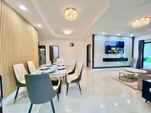 3 Bedroom House for Rent at Ekmongkol 1 Village open-plan dining room with modern chairs and adjacent TV lounge