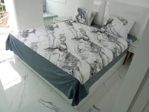 Studio Condo for Sale at The Empire Tower Pattaya bed with marble-patterned linens and nightstands