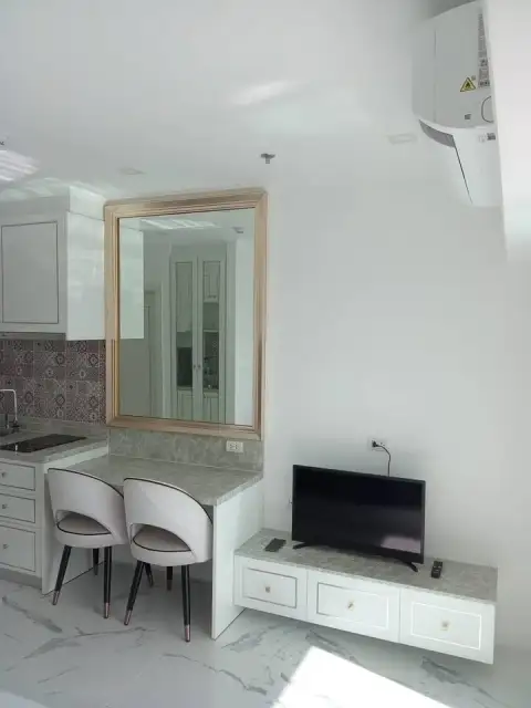 Studio Condo for Sale at The Empire Tower Pattaya living area with TV, mirror and dining chairs