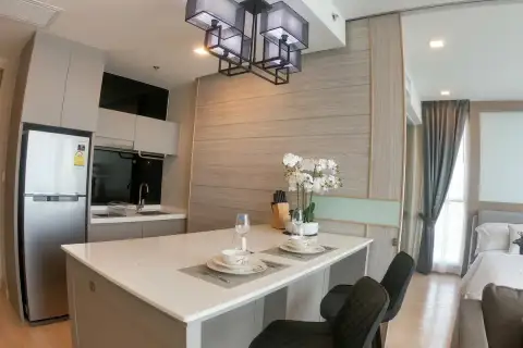 1 Bedroom Condo for Sale at Cetus Beachfront modern kitchen with white island countertop, stainless steel fridge, and pendant light