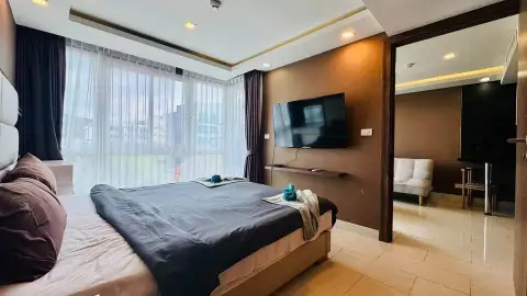 1 Bedroom Condo for Sale at Grand Avenue Residence bedroom with wall-mounted TV and city view window