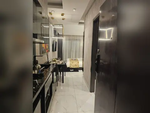 Studio Condo for Sale at Grand Solaire Noble bathroom vanity with LED mirror and dark marble tiling