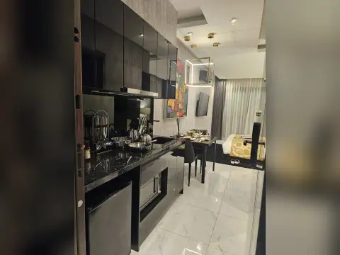 Studio Condo for Sale at Grand Solaire Noble bathroom entrance with illuminated mirror and black marble walls