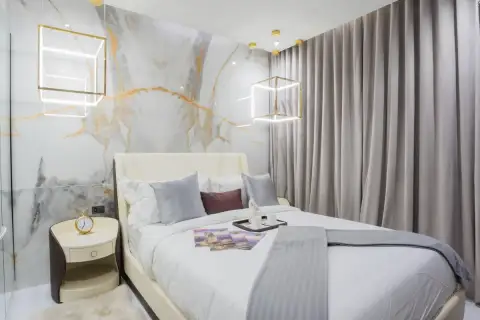 1 Bedroom Condo for Sale at Grand Solaire Pattaya bedroom with gold marble feature wall, upholstered bed and geometric pendant lights