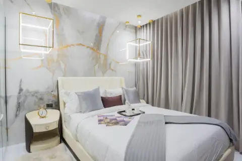 1 Bedroom Condo for Sale at Grand Solaire Pattaya bedroom with marble accent wall and gold cube pendant lights