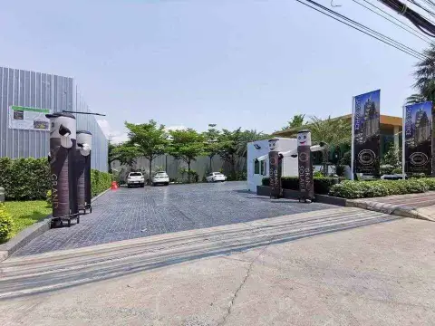 1 Bedroom Condo for Sale at Grand Solaire Pattaya driveway entrance with sales office banners and parked cars
