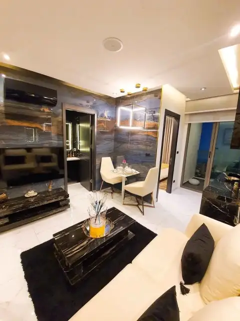 1 Bedroom Condo for Sale at Grand Solaire Pattaya living room with marble accent wall, dining table, and city view balcony