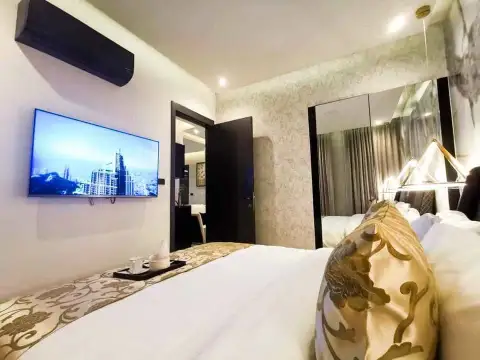 1 Bedroom Condo for Sale at Grand Solaire Pattaya bedroom with wall-mounted TV, mirrored headboard, and plush pillows