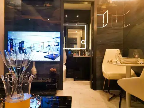 1 Bedroom Condo for Sale at Grand Solaire Pattaya dining area with TV showing fitness center and marble bathroom entrance