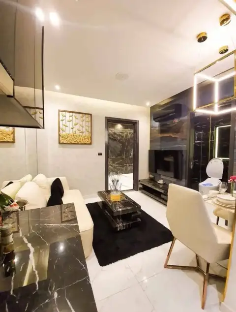 1 Bedroom Condo for Sale at Grand Solaire Pattaya open-plan living area with dining table, sofa and TV near bathroom