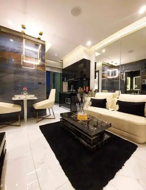 1 Bedroom Condo for Sale at Grand Solaire Pattaya living room with marble accent wall, cube pendant light and black coffee table