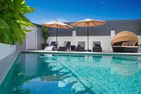 Grand Tanyawan Home large community swimming pool with houses and blue sky in the background.