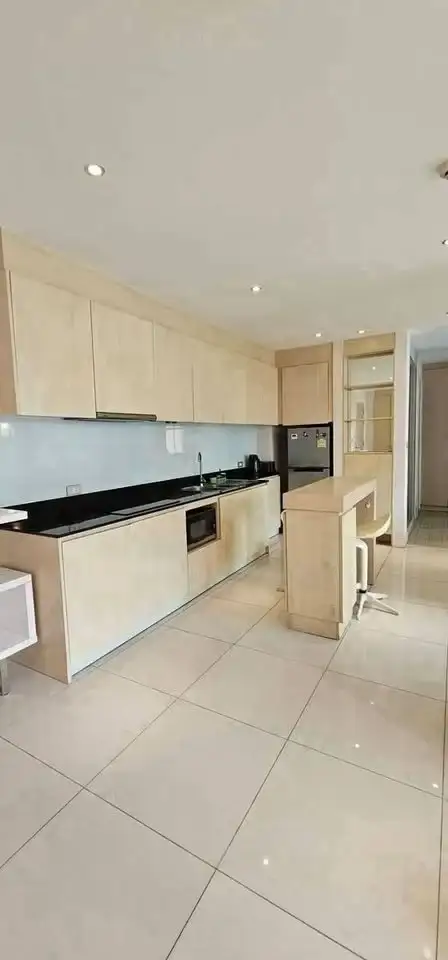 2 Bedroom Condo for Sale at Grande Caribbean kitchen with wood cabinetry, black counters and breakfast bar