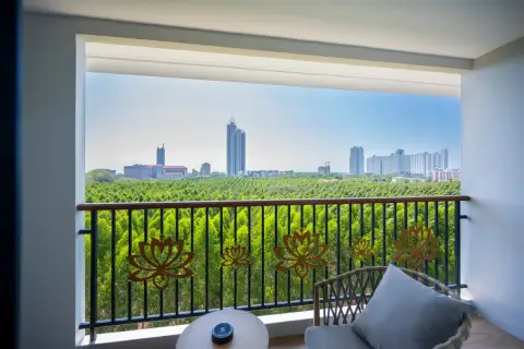 1 Bedroom Condo for Sale at Wyndham Jomtien Pattaya: Living area with sofa, kitchenette, and wooden entrance door.