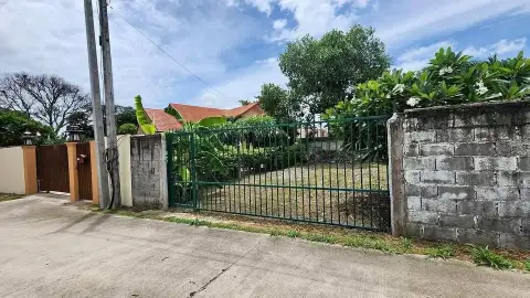 2 Bedroom House for Sale in Huai Yai green metal gate entrance and perimeter wall with banana trees