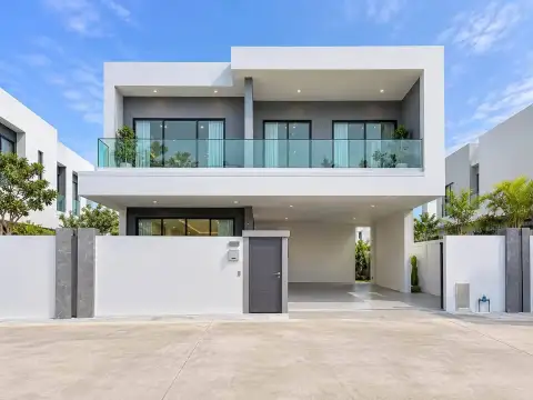 5 Bedroom House for Sale & Rent in Huai Yai two-story white modern house exterior with glass balcony and carport