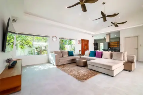 5 Bedroom House for Sale & Rent in Huai Yai living room with sectional sofa, ceiling fans, and open kitchen view