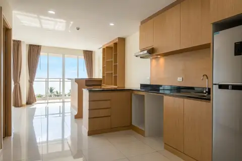3 Bedroom Condo for Sale at Whale Marina open-plan kitchen with wooden cabinets, black countertops and sea view balcony