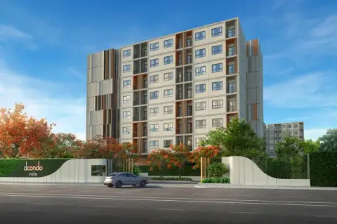 Dcondo Vale Sriracha condo building exterior with entrance signage and tree-lined street view