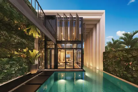 Inara Villa modern exterior with glass walls, pink-lit swimming pool, outdoor sofa, and lush greenery at dusk.