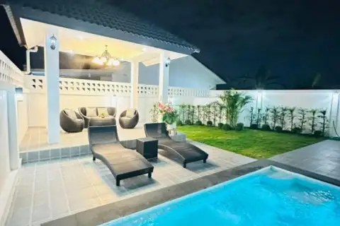 4 Bedroom House for Sale at Rattanakorn Village 18: Poolside view with lounge chairs, covered patio, and outdoor furniture.