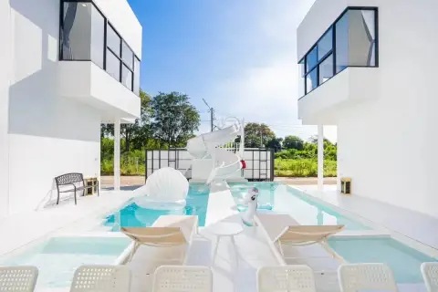 10 Bedroom House for Sale in Jomtien daytime courtyard pool with water slide and pool floats between wings