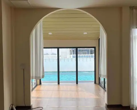 5 Bedroom House for Rent in Jomtien archway leading to room with pool view through glass doors
