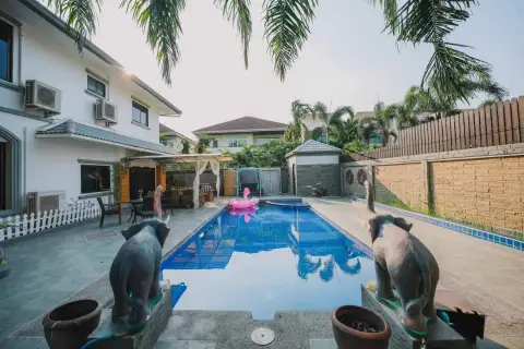 7 Bedroom House for Rent in Jomtien backyard pool with flamingo float, elephant statues, and patio seating