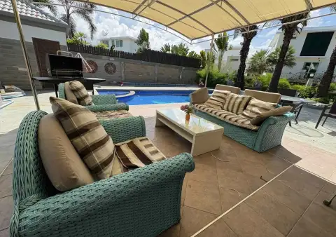 7 Bedroom House for Rent in Jomtien covered poolside lounge area with wicker sofas and BBQ grill