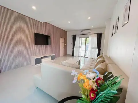 3 Bedroom House for Rent in East Pattaya open living area with sectional sofa, TV wall and bright window view