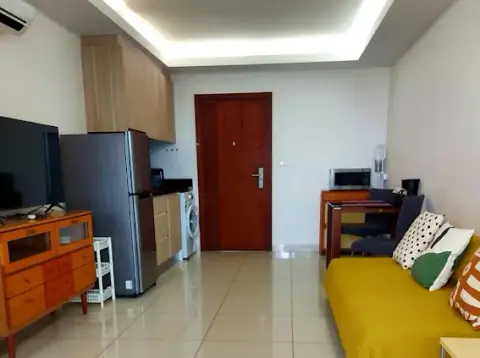 1 Bedroom Condo for Sale at Laguna Beach Resort 1 living space with yellow sofa, wooden door, and kitchenette