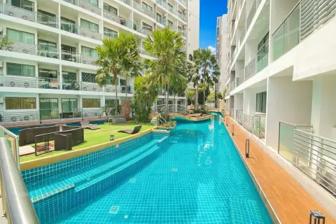 Laguna Beach Resort 1 long, narrow swimming pool between two condo buildings, with artificial grass and loungers.