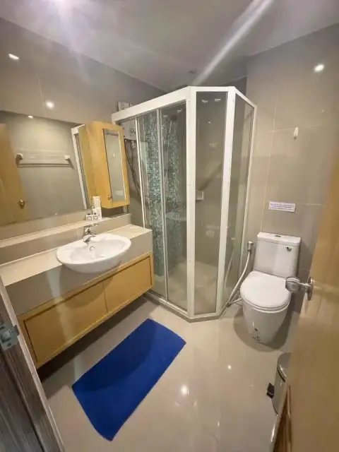 2 Bedroom Condo for Rent at Lanna Condo bathroom with corner glass shower, sink and blue bath mat