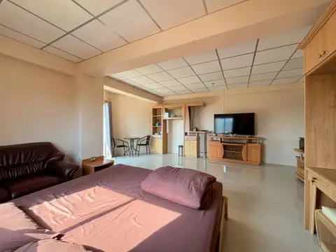 2 Bedroom Condo for Sale at Jomtien Beach Condominium open-plan living area with bed, TV unit, and dining table