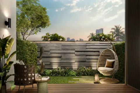 Level Pratumnak condo building exterior aerial view showing gold facade, rooftop garden and beachside palm tree surroundings