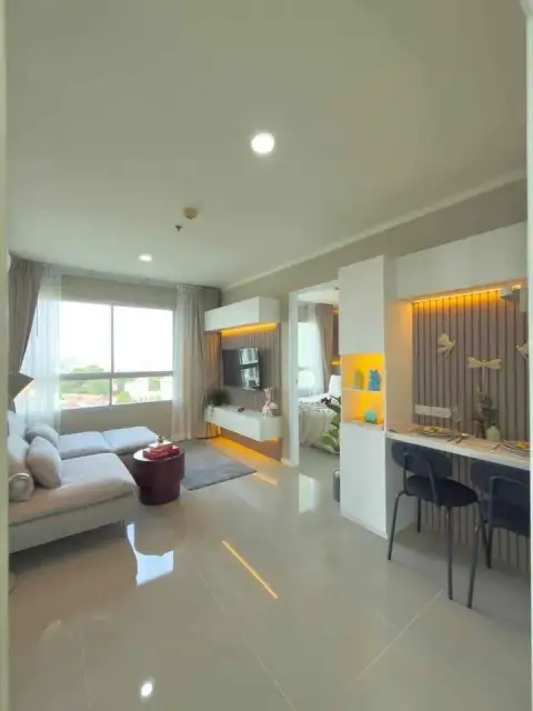 1 Bedroom Condo for Sale at Lumpini Ville Naklua-Wongamat living and dining space with sofa, TV unit and natural light