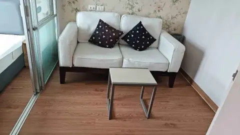 1 Bedroom Condo for Rent at Lumpini Ville Naklua-Wongamat living area with sofa and wooden flooring