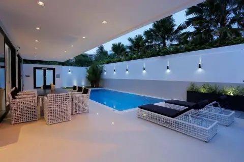 8 Bedroom House for Sale in Pratumnak Hill poolside patio with lounge chairs and outdoor dining at dusk