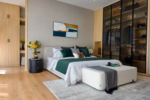 4 Bedroom House for Sale at Luxury Vista Villas master bedroom with green accents, glass-door walk-in wardrobe, and wood floors