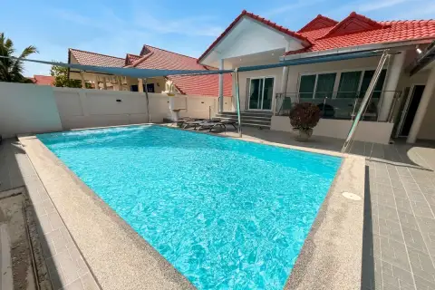 Royal Prestige spacious outdoor private pool with shade sail, lounge chairs, and glass balustrade terrace