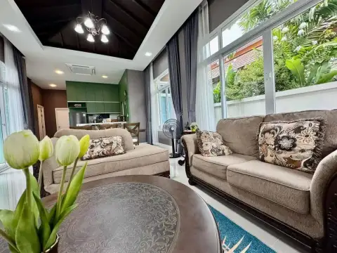 2 Bedroom House for Rent in Mabprachan cozy lounge with tulip flowers and large windows overlooking garden